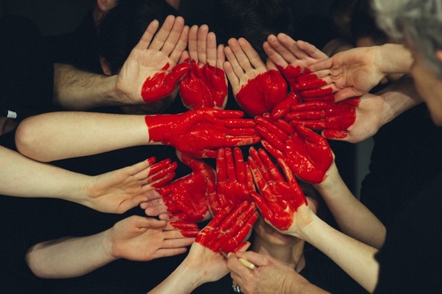 Red heart painted on volunteers hands